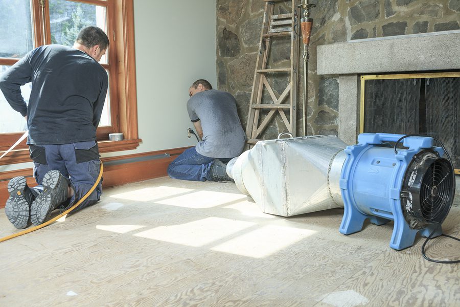 HVAC technicians working on in home ventilation system.